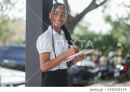 Young African woman using tablet and stylus outdoors while looking away, concept of digital planning, mobile workflow, creative productivity and modern flexible work lifestyle. 139259134