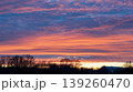 Dramatic colorful sunset sky with vibrant clouds over rural trees 139260470
