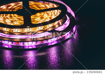 LED strip lights glowing with colorful illumination on dark background, modern lighting technology LED strip lights glowing with colorful illumination on dark background, modern lighting technology 139260881