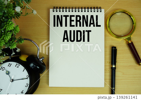 Internal Audit text written on notepad with alarm clock and magnifying glass flat lay on wooden background Internal Audit text written on notepad with alarm clock and magnifying glass flat lay on wooden background 139261141