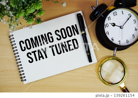 Coming Soon Stay Tuned text written on notepad with alarm clock and magnifying glass flat lay on wooden background Coming Soon Stay Tuned text written on notepad with alarm clock and magnifying glass flat lay on wooden background 139261154