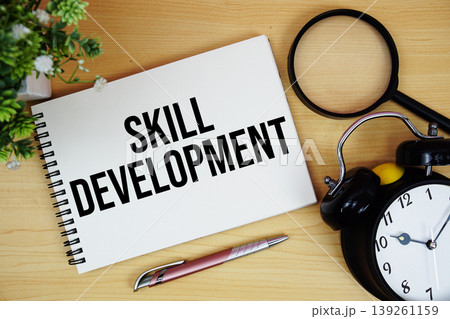 Skill Development text written on notepad with alarm clock and magnifying glass flat lay on wooden background Skill Development text written on notepad with alarm clock and magnifying glass flat lay on wooden background 139261159