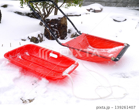 積もった雪の上に置かれた赤いソリとスノーダンプ 139261407