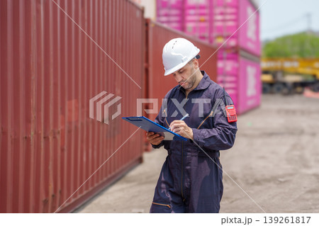 Mid-adult Caucasian male port inspector reviewing inventory on clipboard at Asian shipping container terminal. Mid-adult Caucasian male port inspector reviewing inventory on clipboard at Asian shipping container terminal. 139261817