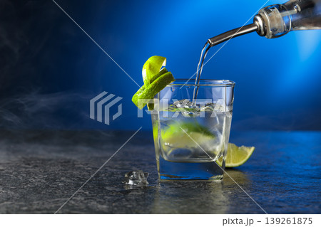 Vodka with lime and ice cubes in a fogged up glass. Vodka with lime and ice cubes in a fogged up glass. 139261875