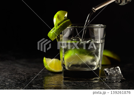 Vodka with lime and ice cubes in a fogged up glass. Vodka with lime and ice cubes in a fogged up glass. 139261876