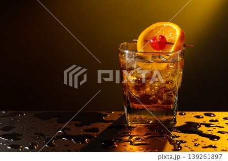 Old fashioned cocktail in a sweating glass on a wet black table. 139261897