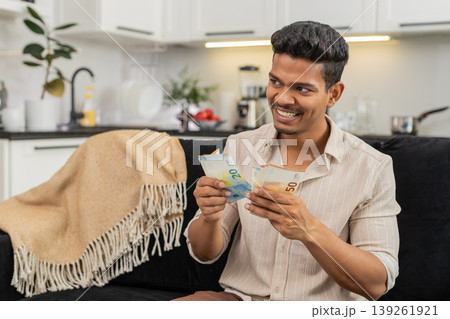 Indian man counts euro cash happy makes money gesture plans dream purchase savings bonus invest plan 139261921