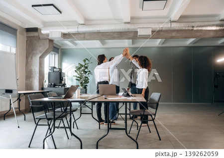 Celebrating, doing high five. Group of people are working in the office together as a team Celebrating, doing high five. Group of people are working in the office together as a team 139262059