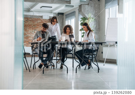 Brick wall is behind. Group of people are working in the office together as a team Brick wall is behind. Group of people are working in the office together as a team 139262080