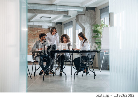 Unfinished room, brick wall. Group of people are working in the office together as a team Unfinished room, brick wall. Group of people are working in the office together as a team 139262082