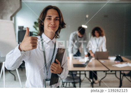 Thumb up hand gesture. Group of people are working in the office together as a team 139262125