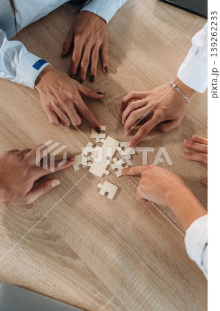Focused top view of office workers that are playing puzzle game, conception of success 139262233