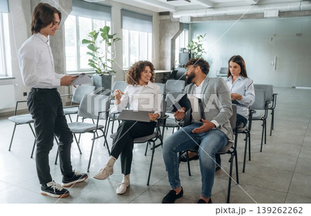 Guy is talking to a man. People are sitting on the meeting, education presentation, business conception Guy is talking to a man. People are sitting on the meeting, education presentation, business conception 139262262