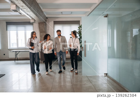In the hall. Four office workers are together, employees at work In the hall. Four office workers are together, employees at work 139262384