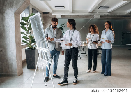 Plan of the project, on the board. Four office workers are together, employees at work 139262401