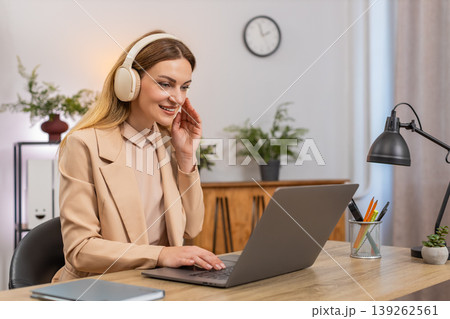 Businesswoman types report with earphones calm music focus rhythm nod focused look productive flow Businesswoman types report with earphones calm music focus rhythm nod focused look productive flow 139262561