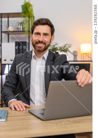 Middle-aged businessman opens laptop with big smile starts typing fast fresh start of new work day 139262568
