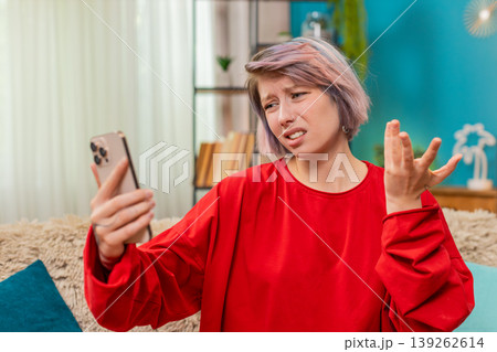 Woman making angry emotional video call argument on smartphone, gesturing irritated annoyed reaction Woman making angry emotional video call argument on smartphone, gesturing irritated annoyed reaction 139262614