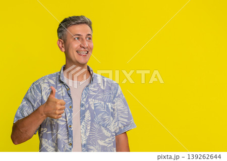 Man smiling confidently showing thumbs up approval gesture with hand to express trust and support Man smiling confidently showing thumbs up approval gesture with hand to express trust and support 139262644