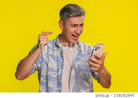 Adult man yelling at smartphone angrily arguing during call pressing end button with hand gestures 139262645