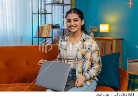 Indian woman closes laptop on sofa with relief satisfied finishing work looking camera breathing out 139262921