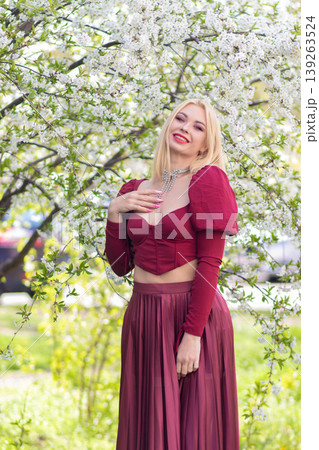 Joyful Blonde Woman In Burgundy Fashion With Spring Blossoms Joyful Blonde Woman In Burgundy Fashion With Spring Blossoms 139263524