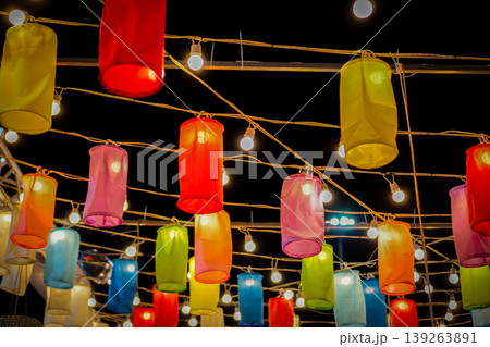 Celestial Canopy: A mesmerizing display of vibrant paper lanterns, illuminated by twinkling bulbs, casts a warm, inviting glow against a deep twilight.  139263891