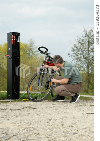 Maintenance of a mountain bike at a public repair pillar. Maintenance of a mountain bike at a public repair pillar. 139264373