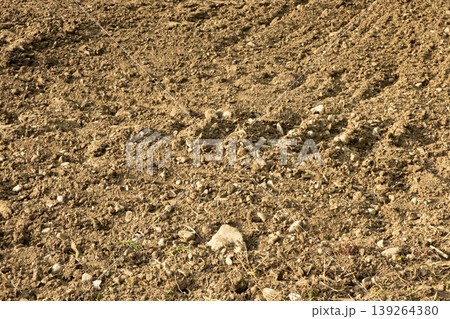 A farmers field with many stones. Natural soil surface with pebbles. A farmers field with many stones. Natural soil surface with pebbles. 139264380