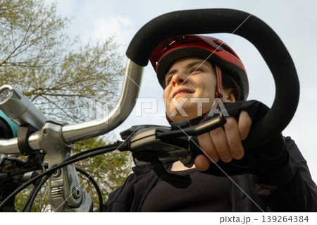 Portrait of a happy female cyclist in a helmet close-up 139264384