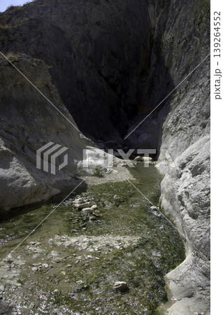 Canyon Creek with Shallow Water and Rocky Walls. A tranquil scene of a calm, shallow stream flowing through a scenic rocky canyon on a sunny day. Canyon Creek with Shallow Water and Rocky Walls. A tranquil scene of a calm, shallow stream flowing through a scenic rocky canyon on a sunny day. 139264552