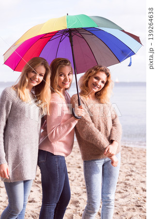 Three women under colorful umbrella Three women under colorful umbrella 139264638