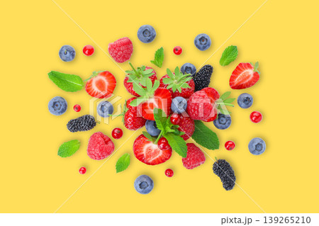 Bright berries and mint leaves lie on a yellow surface Bright berries and mint leaves lie on a yellow surface 139265210