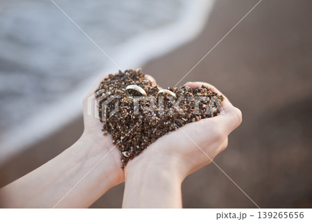 Romantic Wedding Rings on Sand Heart Concept. Marriage Symbol Rings on Heart Shaped Sand Close Up. 139265656