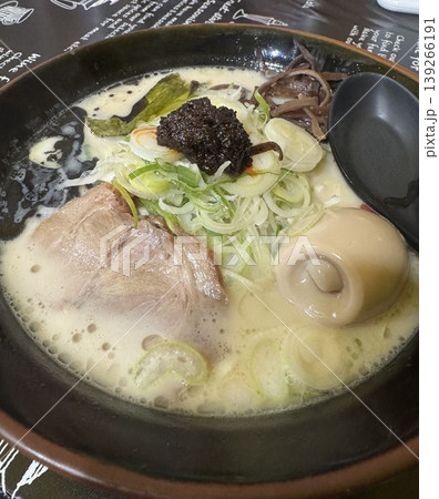 クリーミーな豚骨ラーメンと焦がしにんにくの黒マー油 チャーシューや味玉が乗った濃厚な麺料理のアップ クリーミーな豚骨ラーメンと焦がしにんにくの黒マー油 チャーシューや味玉が乗った濃厚な麺料理のアップ 139266191