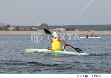 Rear view athlete kayaker paddling on open water 139266998