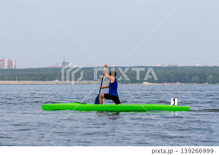 Athlete canoeist paddling on open water Athlete canoeist paddling on open water 139266999