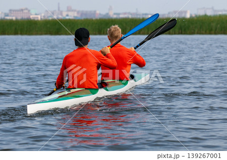 Two young athletes paddling double kayak Two young athletes paddling double kayak 139267001