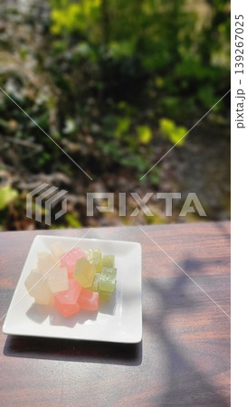 外で楽しむ白い皿に盛られたカラフル和菓子の琥珀糖 外で楽しむ白い皿に盛られたカラフル和菓子の琥珀糖 139267025