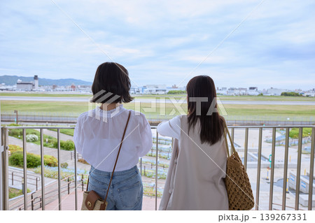 空港の展望デッキから滑走路を眺める二人の女性・友達との旅行や観光のイメージ 139267331