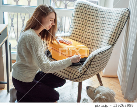 Woman packing suitcase for vacation with dog Woman packing suitcase for vacation with dog 139268989