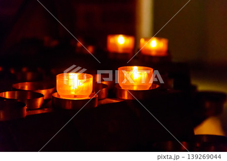 Many burning candles in a church Many burning candles in a church 139269044