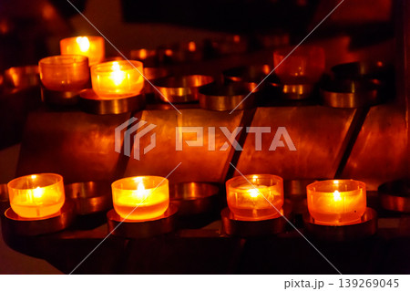 Many burning candles in a church Many burning candles in a church 139269045
