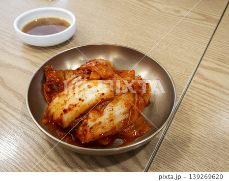 Traditional Korean Spicy Kimchi Served in Brass Bowl on Wood Table 139269620