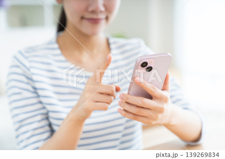 リビングでスマホを使う若い女性の手元 リビングでスマホを使う若い女性の手元 139269834