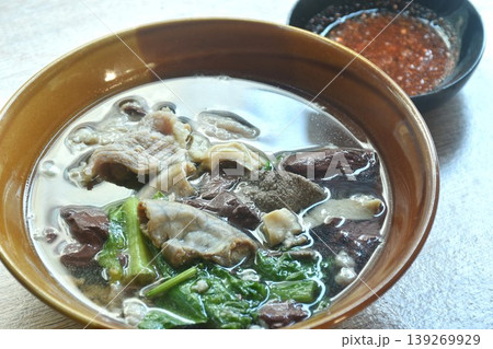 boiled pork blood and entrails with chop pork topping lettuce in soup on bowl dipping spicy sour chili sauce  139269929