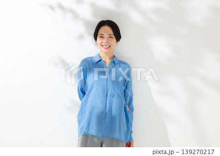 木漏れ日の中に立つ笑顔の女性 木漏れ日の中に立つ笑顔の女性 139270217