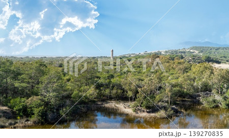 The ancient Roman lighthouse of Patara archaeological site rising above dense green forest in Lycia, Antalya, Turkey The ancient Roman lighthouse of Patara archaeological site rising above dense green forest in Lycia, Antalya, Turkey 139270835