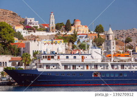 Cruise ship in Symi harbor with waterfront buildings on sunny clear summer day Cruise ship in Symi harbor with waterfront buildings on sunny clear summer day 139270912